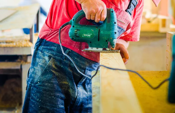 Bir işçi üniforma ve ahşap kesme tahtası ahşap mobilya fabrikası dükkanda giyen adam yakın çekim