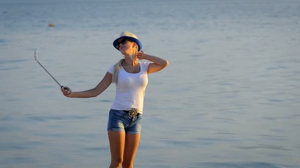 Flicka turist i korta shorts gör selfie på mobiltelefon i en resa vid havet. — Stockvideo