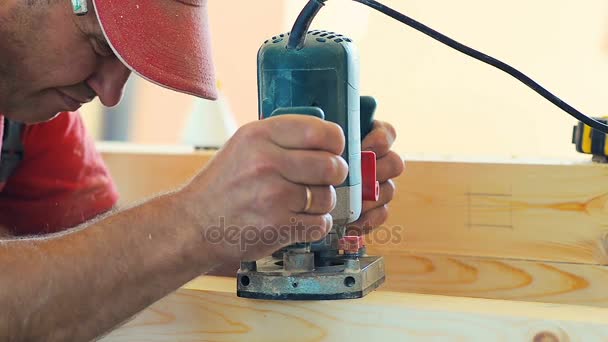 Close-up um homem vestindo trabalhadores uniforme e corte de madeira bordo na oficina de madeira de fábrica de móveis . — Vídeo de Stock