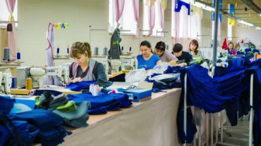 Grup, fabrika işçi kot giyim giysi fabrikasında dikmek. Timelapse.