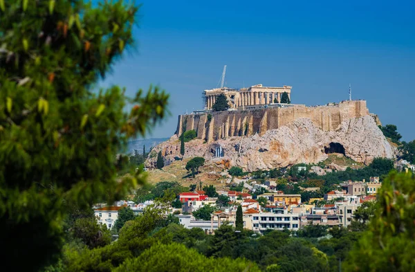 Città di Atene con l'antica Acropoli nel centro della città, vista da dietro l'albero . — Foto Stock