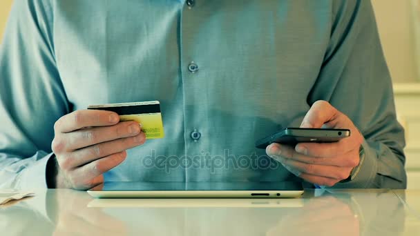 Nahaufnahme Mann nutzt Kreditkarten-Tablet und Smartphone für Online-Einkäufe — Stockvideo