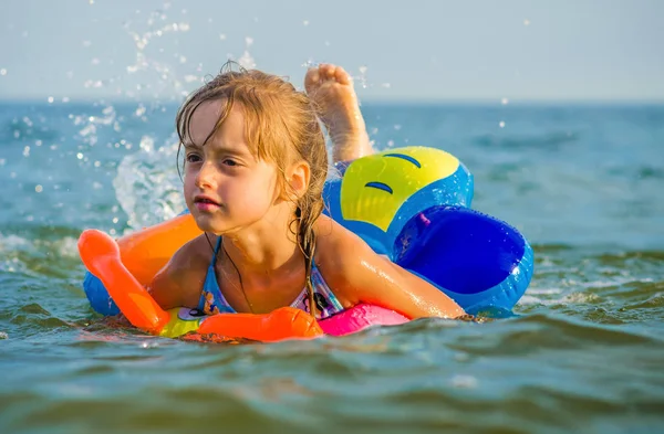 Έξι ετών κορίτσι κολυμπάει στη θάλασσα κάθισε στο δαχτυλίδι καουτσούκ. — Φωτογραφία Αρχείου