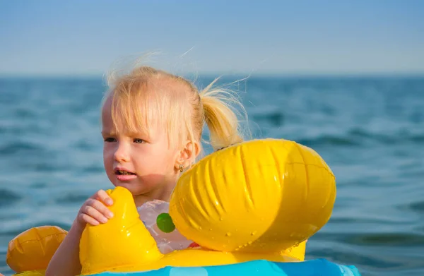 Γκρο πλαν ένα κορίτσι τριών ετών που κολυμπά στη θάλασσα μόνος στον δακτύλιο από καουτσούκ. — Φωτογραφία Αρχείου