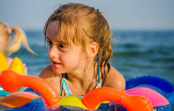 Γκρο πλαν ένα κορίτσι κολυμπάει στη θάλασσα κάθισε στο δαχτυλίδι καουτσούκ και ευτυχισμένα χαμόγελα. — Φωτογραφία Αρχείου