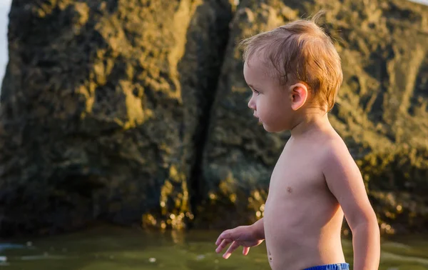 Γκρο πλαν ενός δύο - έτος-παλαιό αγόρι πηγαίνει να κολυμπήσει στη θάλασσα μόνο. — Φωτογραφία Αρχείου
