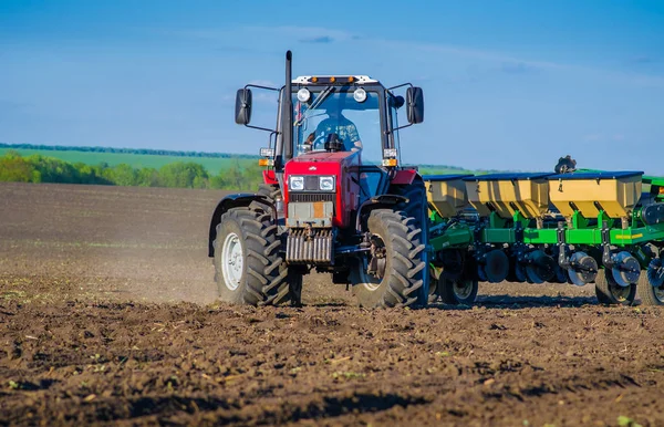 Boerderij trekker zaait het veld met zaden. — Stockfoto