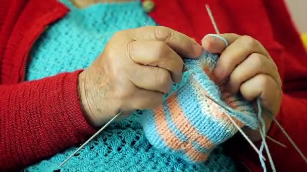 Close-up van de hand van een grootmoeder warme sokken breien voor haar kleinkinderen. — Stockvideo