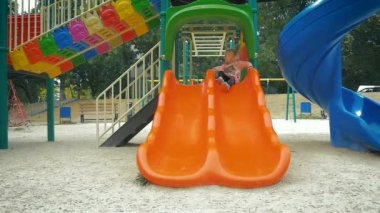 Ağır çekim: kız üç-yıl slayttan parkta geliyor.