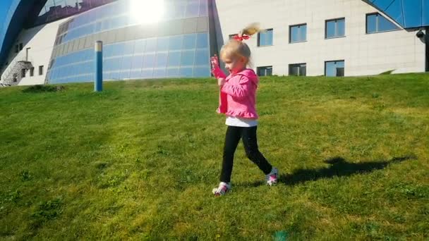 Slow Motion: meisje drie jaar achtereen in het park van de zomer op het groene gazon. — Stockvideo