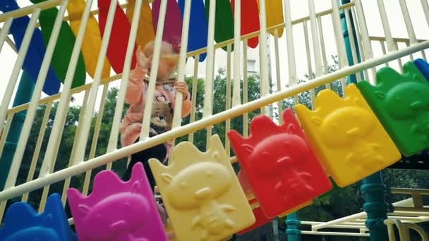 SLOW MOTION: little girl of three-years slowly climbs on the slide. — Stock Video