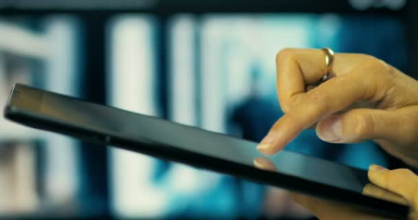 Close-up of a young girl a writing a message to her friends in a social network on a tablet on a TV screen background. — Stock Video