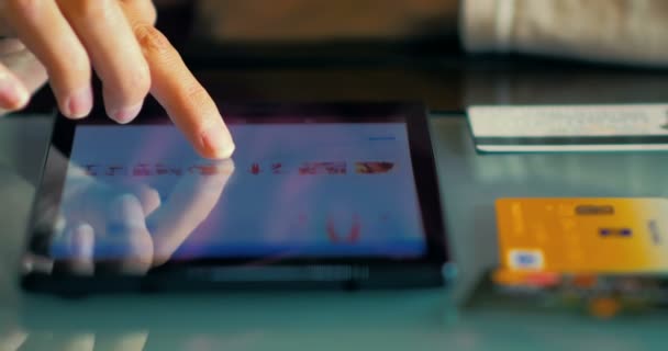 Närbild av en ung flicka titta på varorna i onlinebutiken på tabletten hemma. — Stockvideo