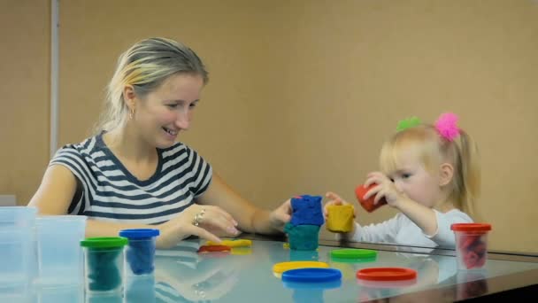 슬로우 모션: 엄마와 3-올해-된 딸이 그녀의 집에서 테이블에 플라스 티 신 타워 구축 하. — 비디오