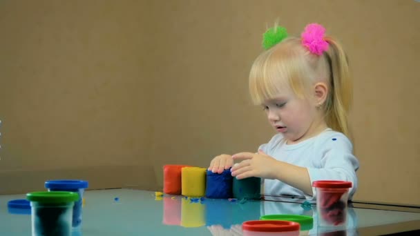 SLOW MOTION : petite fille de trois ans jouait avec de la plasticine à la table à la maison . — Video