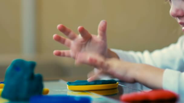 MOCIÓN LENTA: Primer plano de una niña de tres años para esculpir figuras de plastilina en casa . — Vídeo de stock