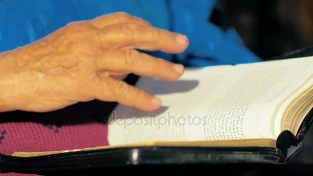 慢动作 八十年的女人慢慢地把圣经的书页变成金色的书页 — 图库视频影像