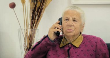 Seksen üç yaşında arkadaşıyla odada bir sandalyede otururken bir telefonda konuşurken, yaşlı Nine.