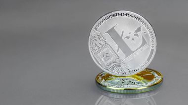 Yakın çekim dijital gümüş Lightcoin altın sikke Bitcoin üzerinde duruyor. Arka plan.