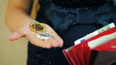 İki cryptocoins - Bitcoin ve Lightcoin yavaş çekimde elinde tutan bir kız Close-Up