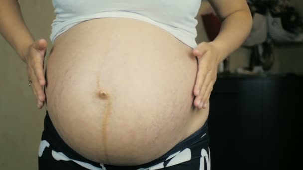 ヶ月で妊娠中の女の子のクローズ アップは 彼女の腹のマッサージ — ストック動画