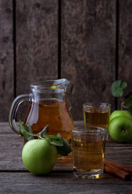 ahşap masa üstünde elma suyu ile gözlük 