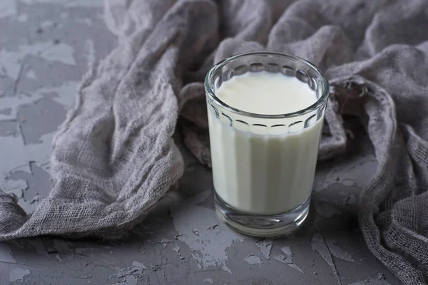 Glass of milk on gray concrete background