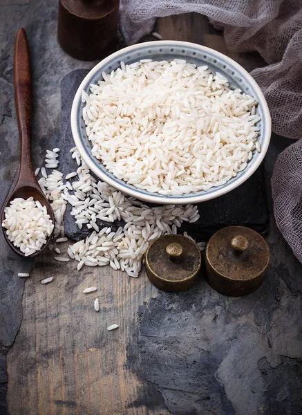 Niegotowane ryż biały na tle konkretnych — Zdjęcie stockowe