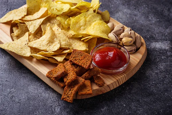 Um lanche variado. Chips, pistácios, nachos e amendoins — Fotografia de Stock