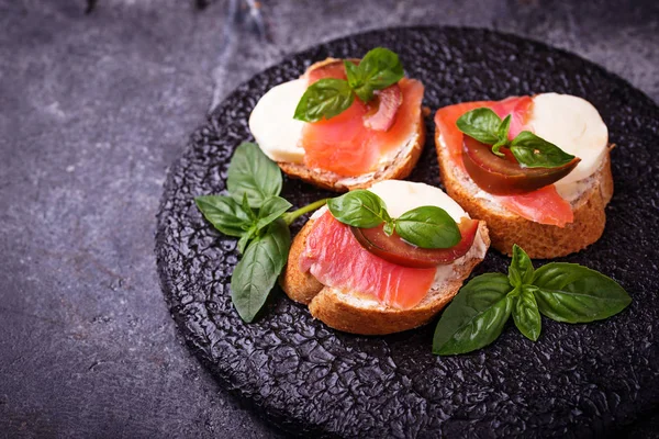 Crostini com salmão, mussarela, tomate e manjericão — Fotografia de Stock