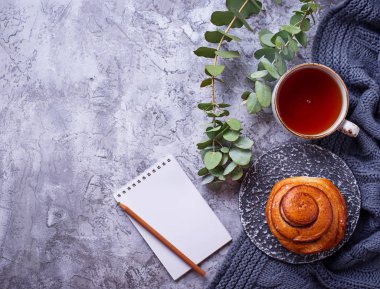 Bun, fincan çay ve defter ile kadınsı çalışma alanı