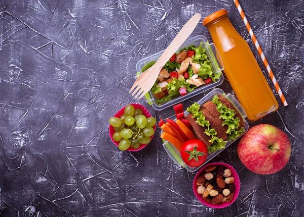 Okul yemeği. Salata, sandviç, meyve ve fındık