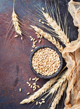 Buğday taneleri ve paslı arka plan üzerinde spikelets