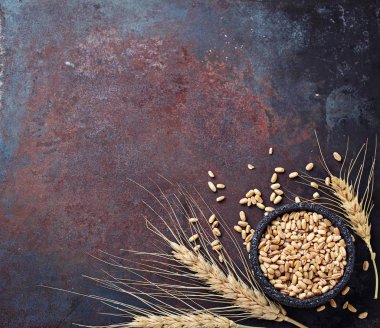 Buğday taneleri ve paslı arka plan üzerinde spikelets