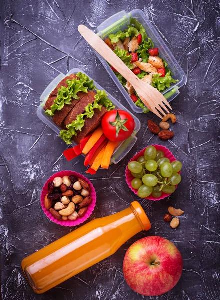 Okul yemeği. Salata, sandviç, meyve ve fındık