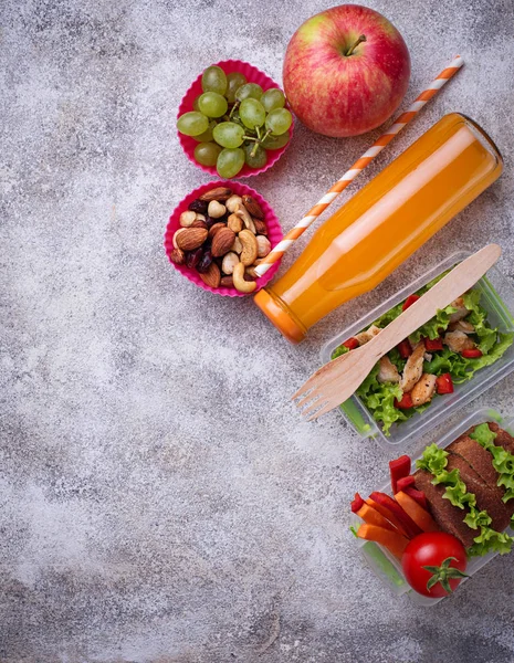 Okul yemeği. Salata, sandviç, meyve ve fındık