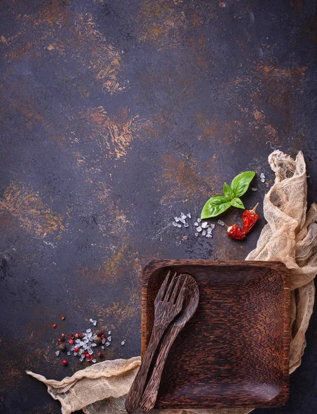 Boş ahşap tabak, çatal bıçak takımı, tuz, biber ve fesleğen