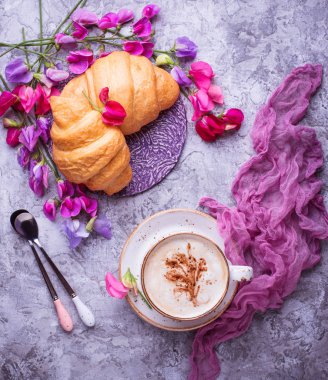 Kahve, kruvasan ve çiçek.