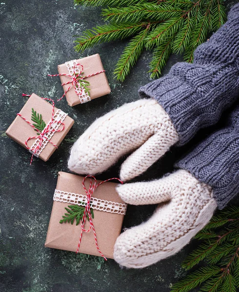 Τα χέρια με γάντια κρατώντας ένα κουτί δώρου Χριστουγέννων — Φωτογραφία Αρχείου