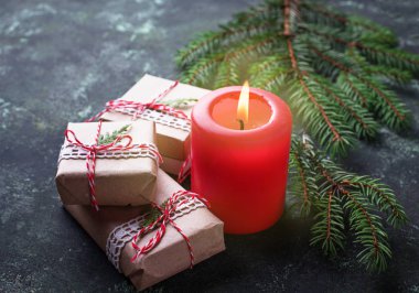 Noel arkaplanı hediye kutuları ve mumlarla dolu.