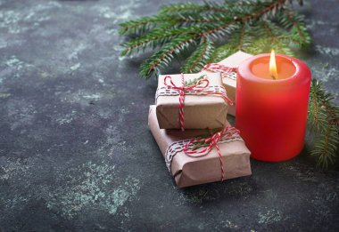 Noel arkaplanı hediye kutuları ve mumlarla dolu.