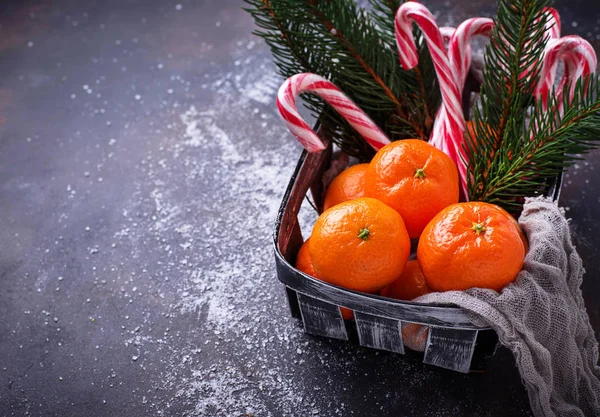 Μανταρίνια και από ζαχαροκάλαμο καραμέλα. Χριστουγεννιάτικο φόντο — Φωτογραφία Αρχείου