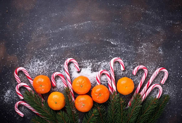 Μανταρίνια και από ζαχαροκάλαμο καραμέλα. Χριστουγεννιάτικο φόντο — Φωτογραφία Αρχείου