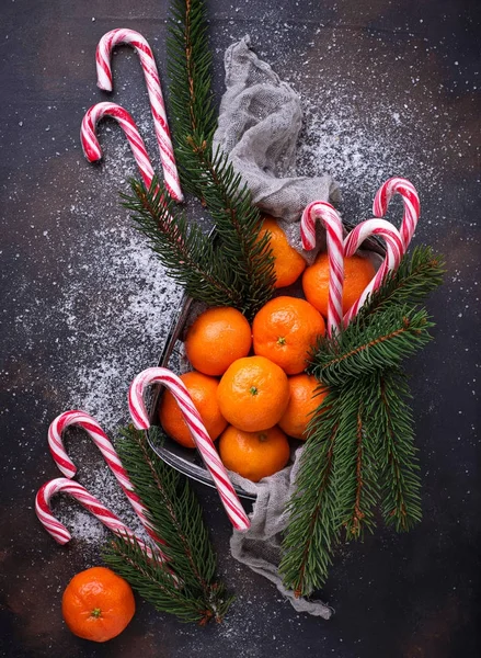 Mandarinky a cukrové třtiny. Vánoční pozadí — Stock fotografie