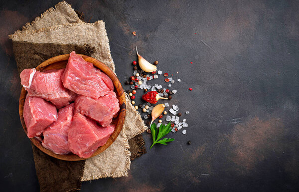 Raw chopped meat with spices on rusty background