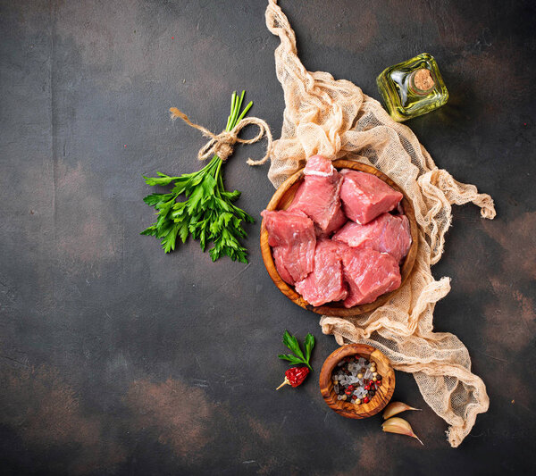 Raw chopped meat with spices on rusty background