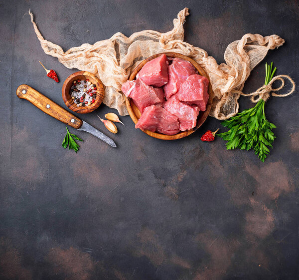 Raw chopped meat with spices on rusty background