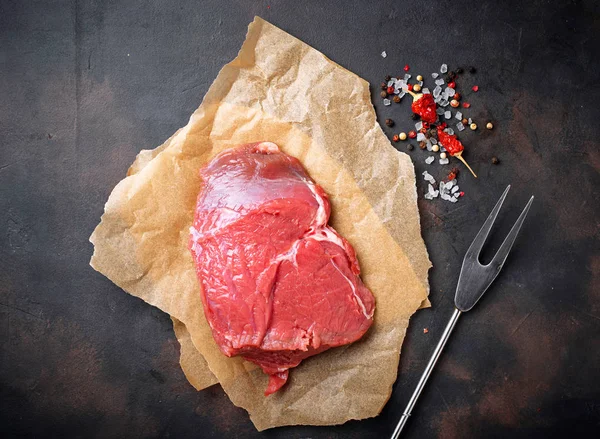 Steak de viande crue avec des épices sur fond rouillé — Photo