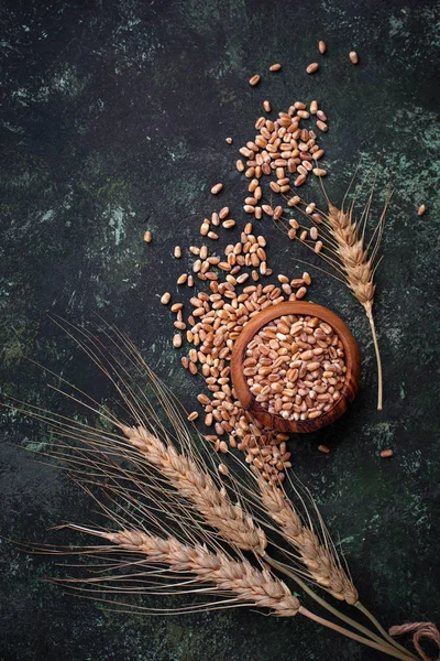 Buğday taneleri ve paslı arka plan üzerinde spikelets.