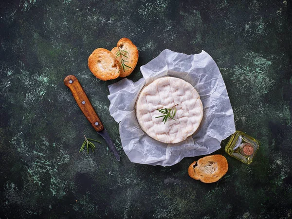 Queijo camembert com alecrim sobre fundo verde — Fotografia de Stock